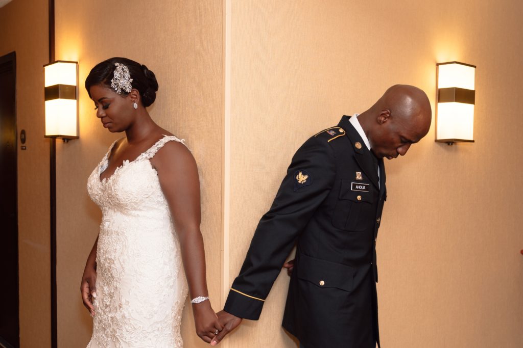 Ivoirian groom and Congolese bride holding hands for first touch before wedding ceremony