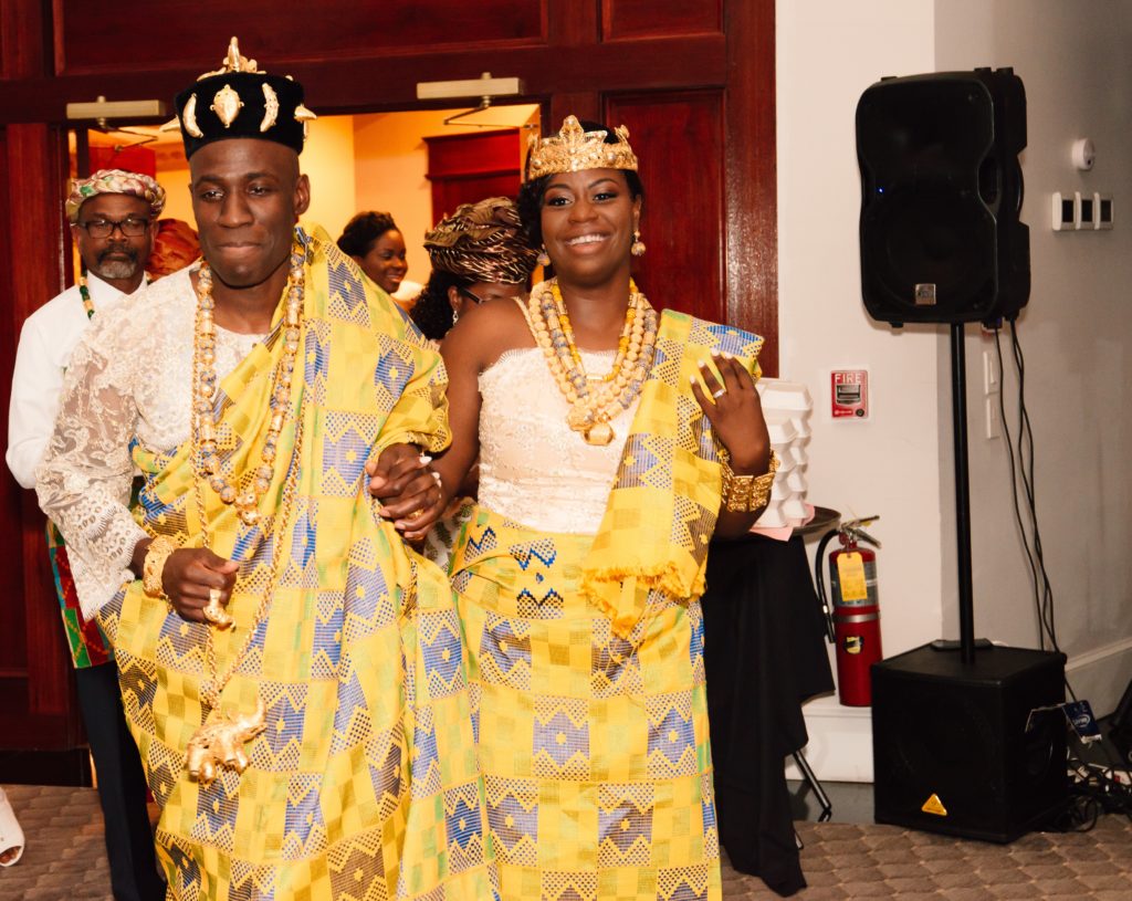 Ivoirian bride and groom at wedding reception in yellow traditional attire